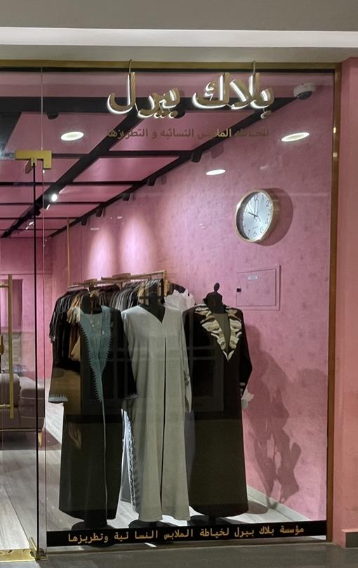 Window display: black abayas with embellished fronts on headless mannequins